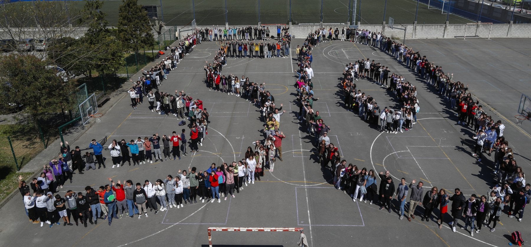 El actual alumnado y profesorado del IES La Albericia de Santander posa en el patio del centro educativo y dibuja un número 50 para celebrar el medio siglo del nacimiento del instituto que se conmemora durante este 2023.