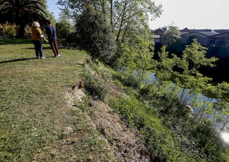 Imagen secundaria 1 - 1. La parcela ha ido perdiendo metros por las mordidas del río desde 2019. | 2. La casa sufre un problema estructural desde entonces, según los vecinos.