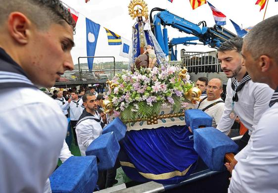 Los picayos embarcan a la virgen pese a hacerlo bajo una intensa lluvia.