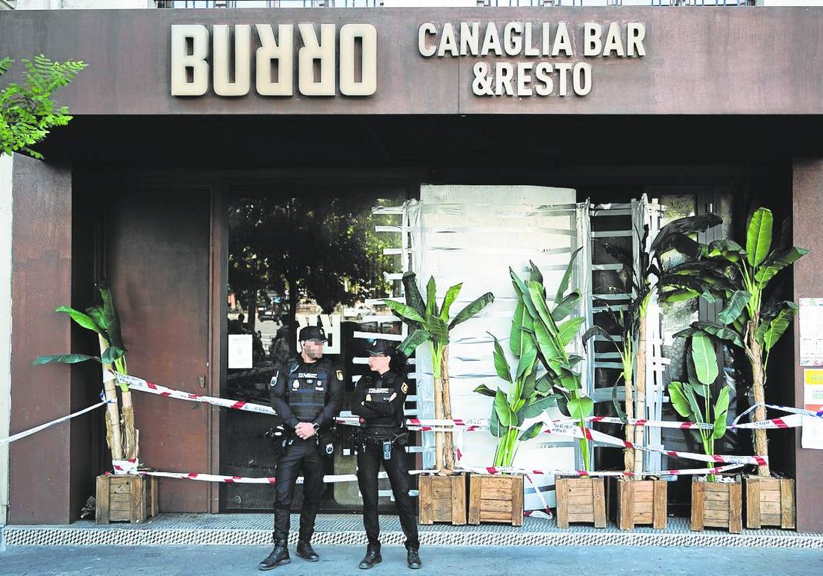 Dos policías, ante la puerta del restaurante Burro Canaglia de Madrid que se incendió el viernes.