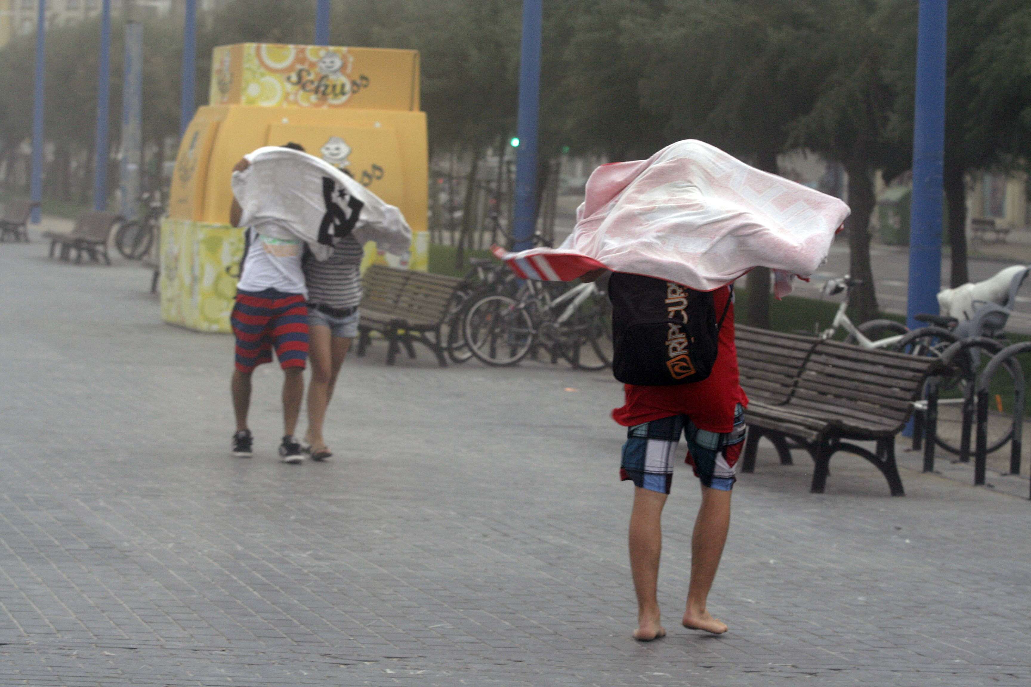 Las toallas suelen ser un buen aliado para protegerse del viento cargado de arena.