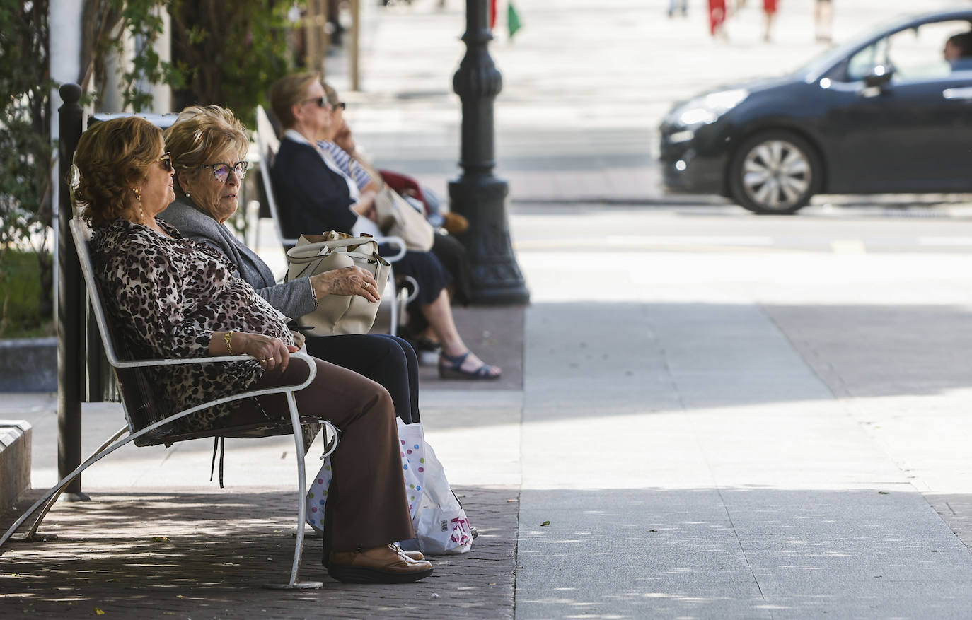 Dos mujeres se refugian, a la sombra, del calor en Torrelavega.