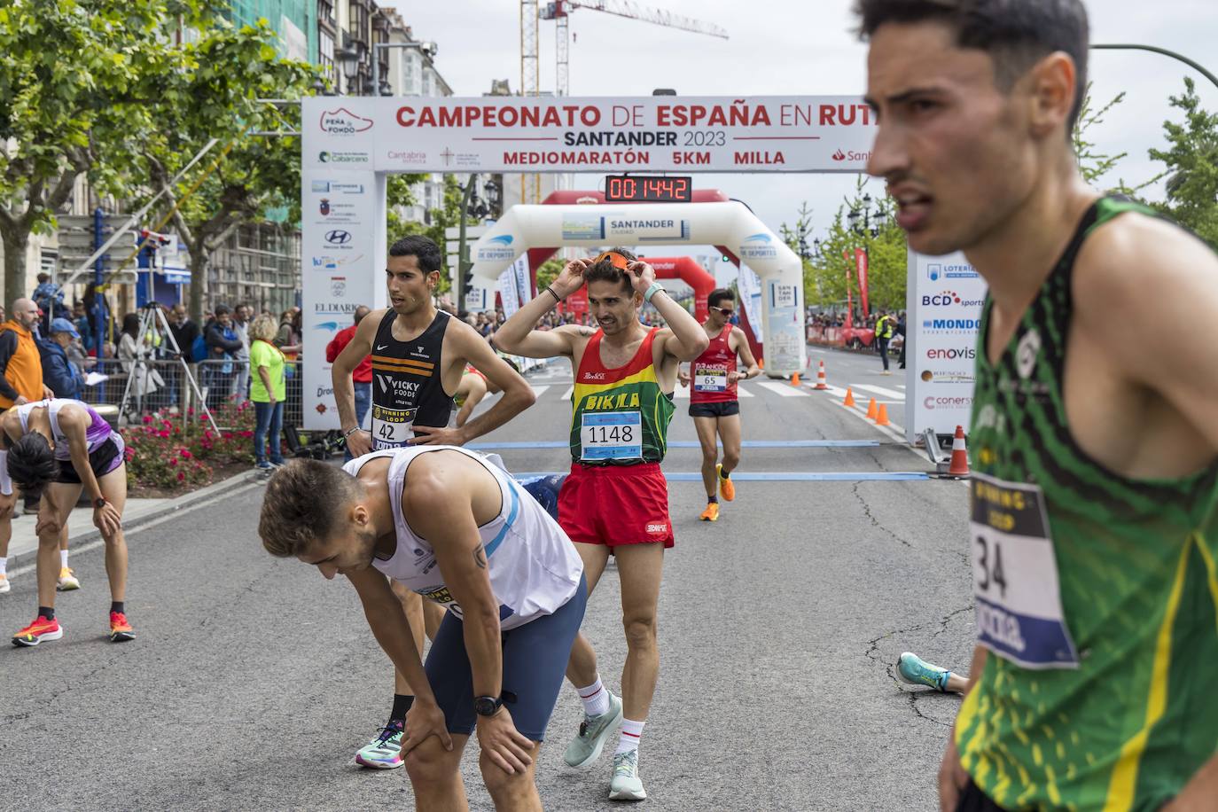 Los participantes, exhaustos, tras la carrera de los cinco kilómetros.