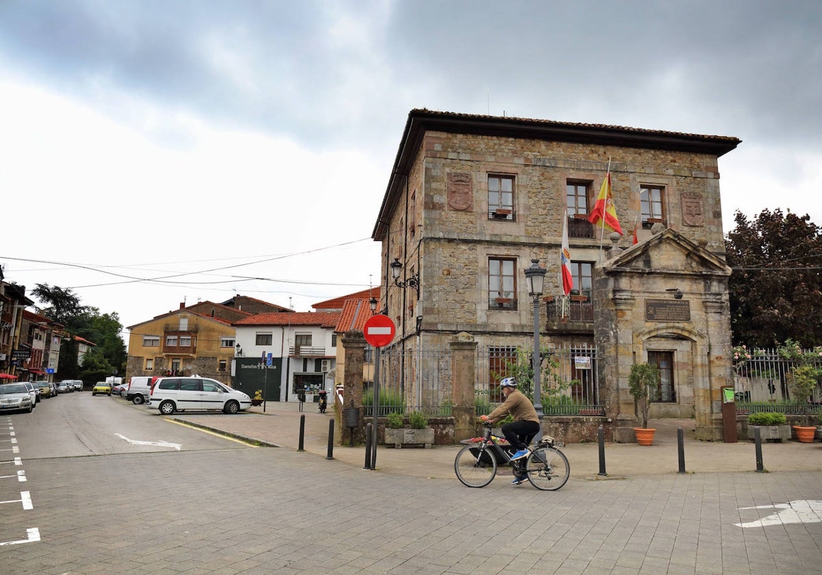 Un hombre atraviesa en bicicleta la plaza del Ayuntamiento.