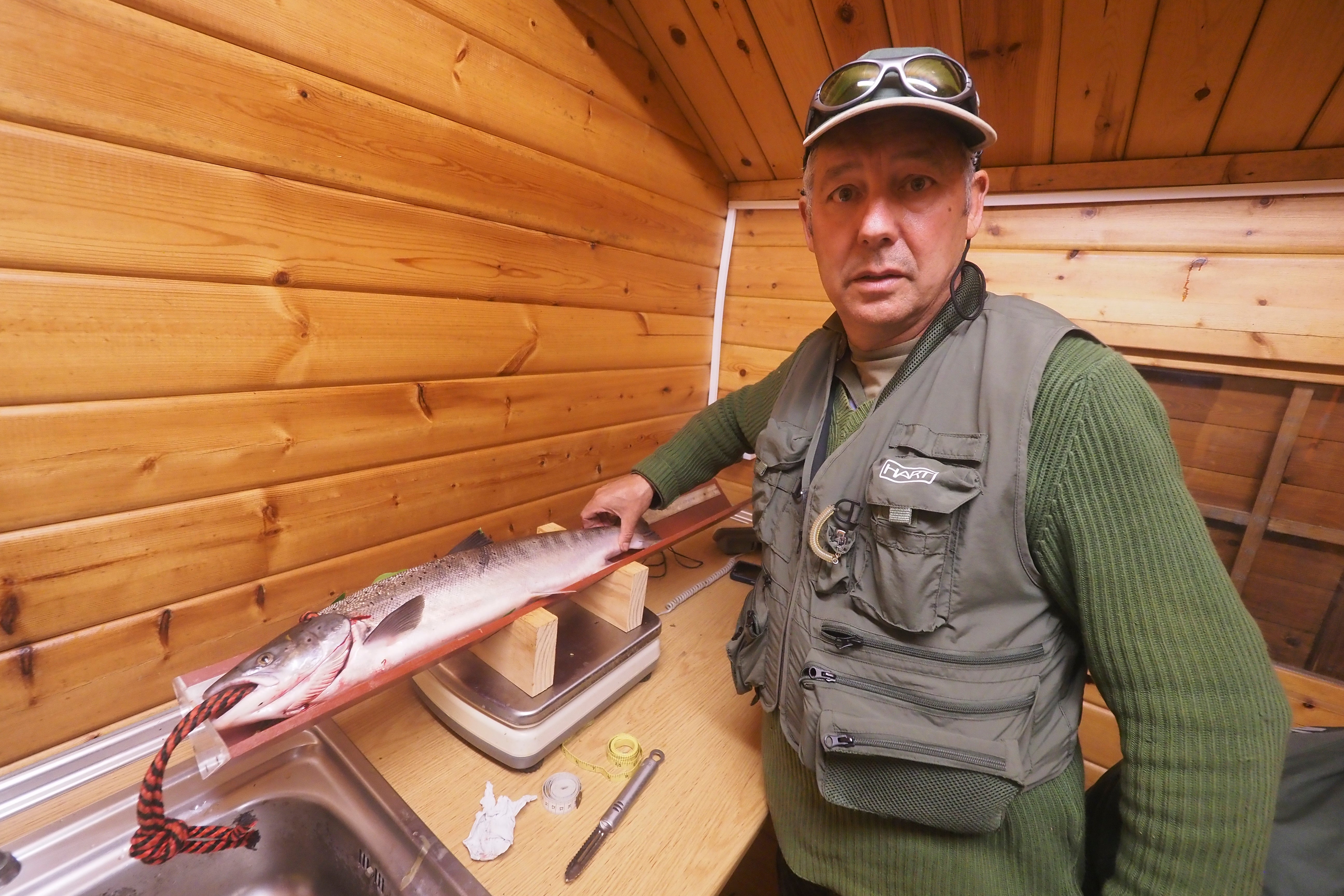 El pescador junto al salmón tras ponerle el precinto.