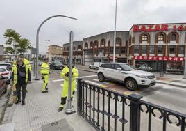 Dos operarios instalan el semáforo en Peñacastillo.