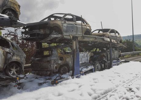 Imagen secundaria 1 - Los vehículos del remolque, totalmente calcinado por las llamas, ocupan la salida hacia Viérnoles (Torrelavega) de la autovía A-67. 