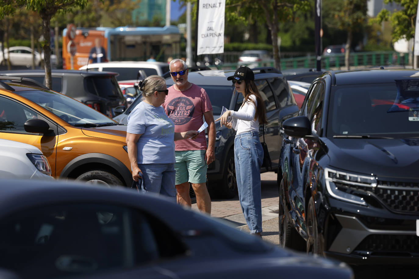 Una pareja recibe información de la representante de un concesionario. 