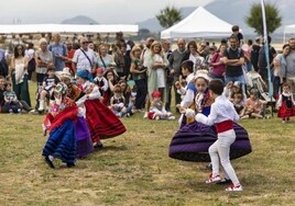 Un grupo de niños, con vestidos tradicionales, bailando.