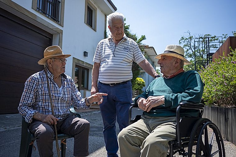 Evaristo Domínguez conversa con dos vecinos en una de las calles de San Miguel de Meruelo.