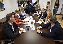 Imagen de los dos equipos negociadores, uno frente a otro.