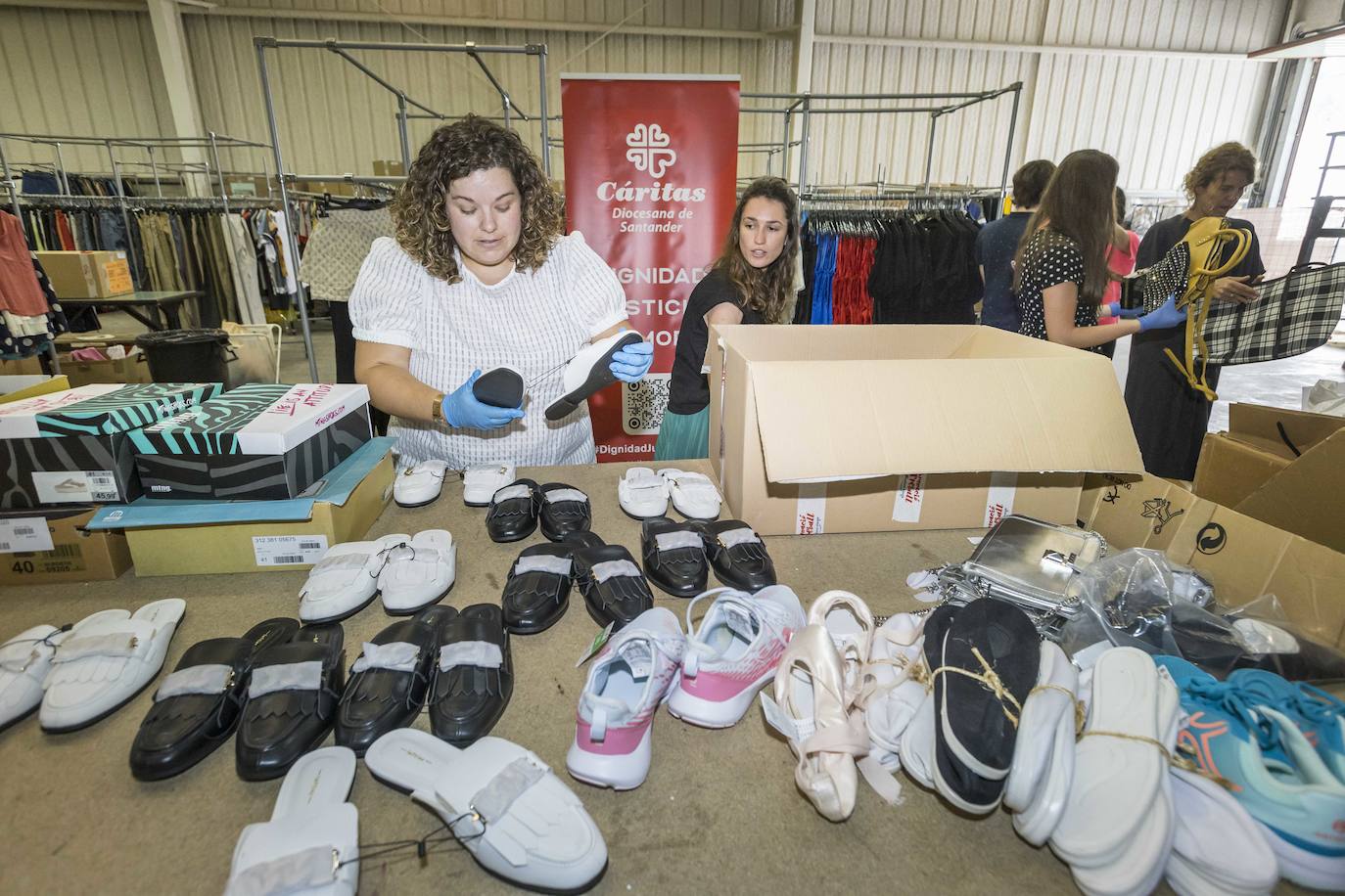 Varias trabajadoras seleccionan el calzado que se ha reciclado.