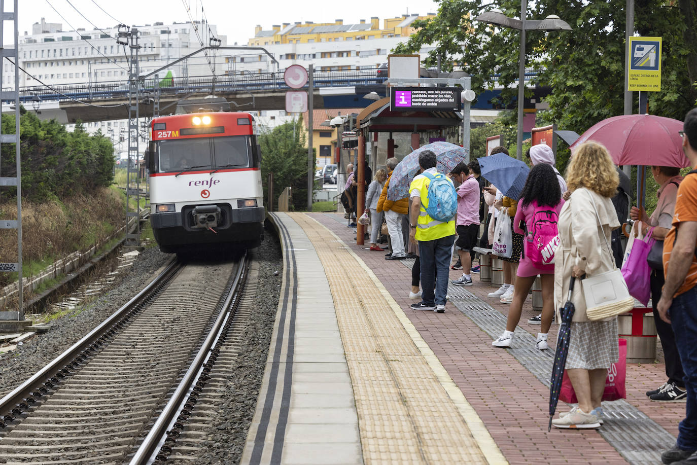 Personas con chalecos fluorescentes informan a los usuarios en la estación de Rende de Muriedas.