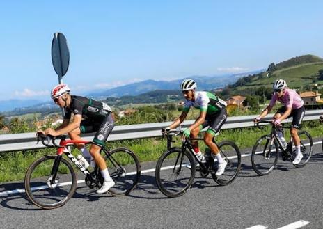 Imagen secundaria 1 - Arriba, el andaluz David González entra en la meta de Santillana sabiendo ya que se iba a vestir de amarillo. Abajo, los escapados en el kilómetro 100 de carrera; y el speaker del Circuito Montañés 2023, Juan Mari Guarjardo, charlando con el líder de la prueba en el podio.