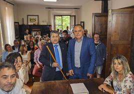 El nuevo alcalde de Cabezón de la Sal, Óscar López, posa con el bastón de mando junto al saliente, Víctor Reinoso.