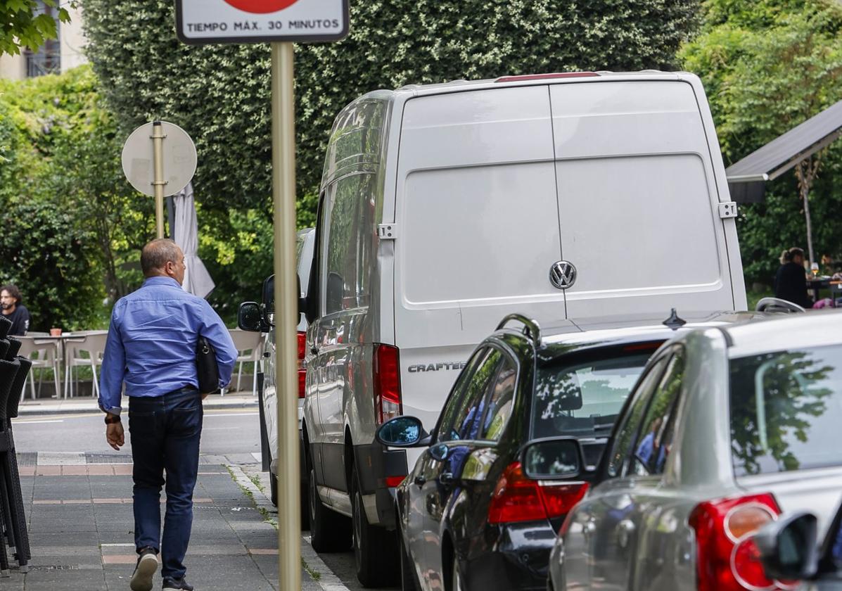 Un vecino camina cerca de una de las zonas afectadas por la ERA en Torrelavega, en la Avenida de España.