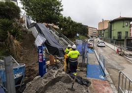 Varios operarios trabajan en las obras del itinerario mecánico entre Jesús de Monasterio y Juan XXIII, a la altura del parque Recaredo, en Cisneros. Los operarios, ayer, tapando las escaleras mecánicas por la lluvia.