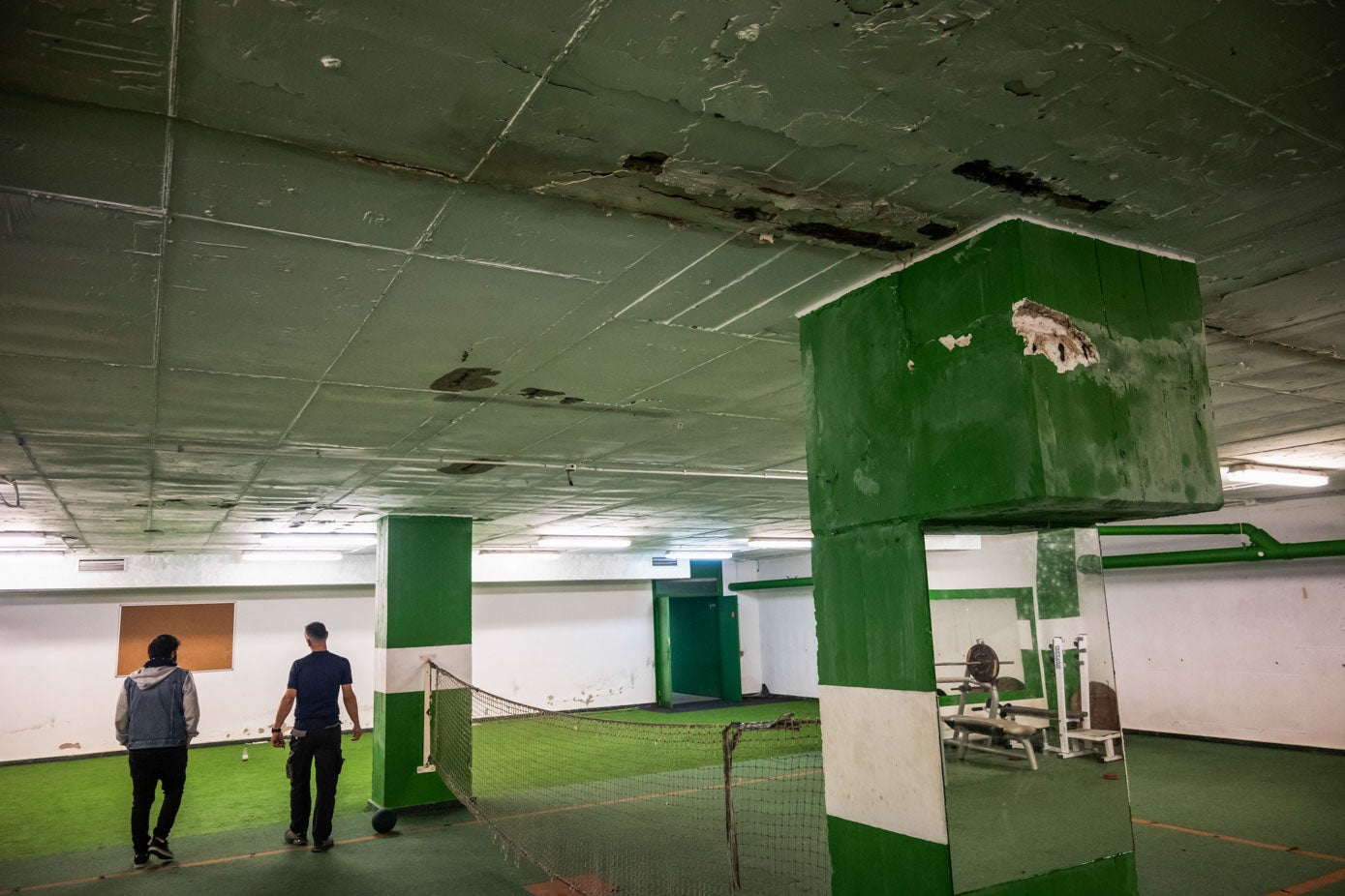 El gimnasio interior del estadio, con goteras y desperfectos en el techo, paredes y columnas.