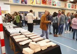 Papeletas y votantes en un colegio electoral de Torrelavega en las elecciones generales de 2019.