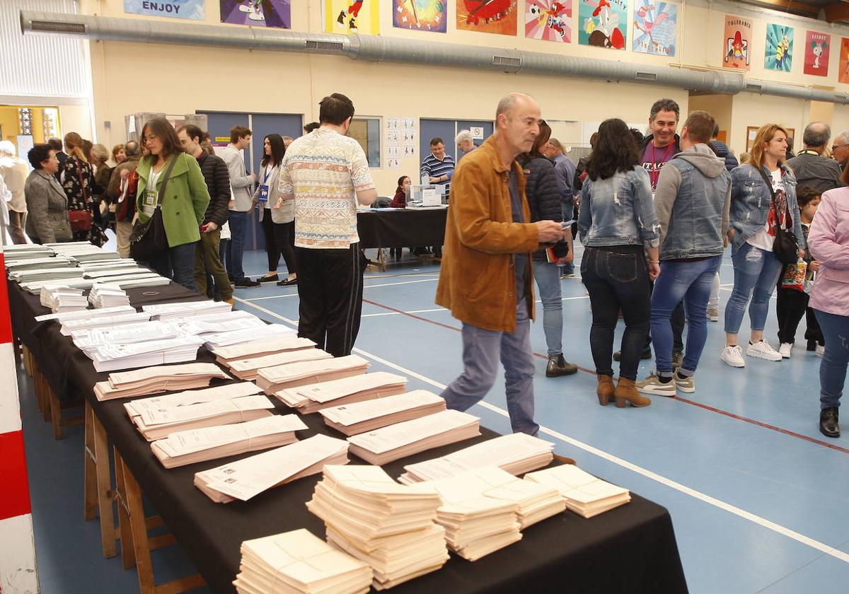 Papeletas y votantes en un colegio electoral de Torrelavega en las elecciones generales de 2019.