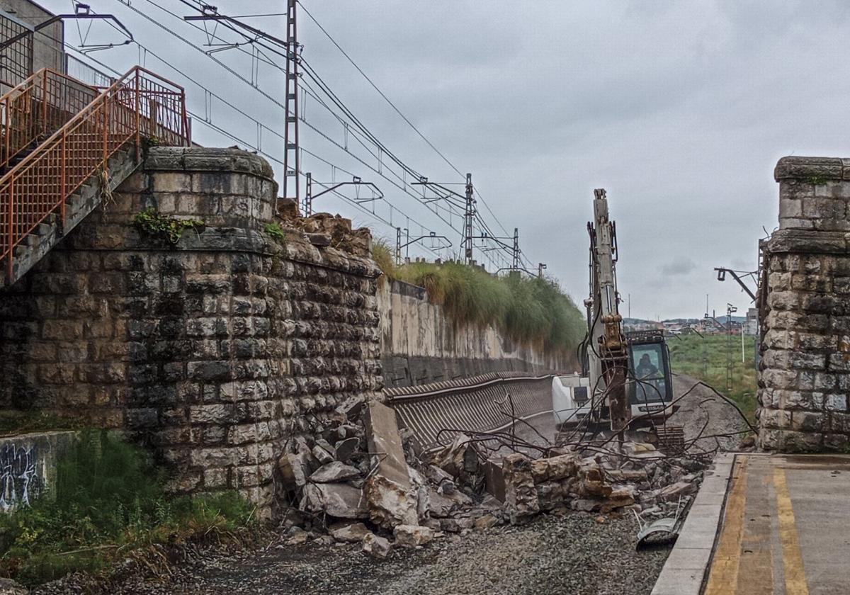 Un operario trabaja picando con una retroexcavadora la piedra del puente derribado en el apeadero de Nueva Montaña, incluido en las obras de la duplicación de la vía entre Santander y Muriedas.