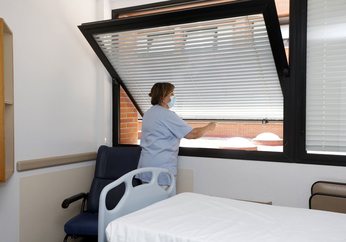 Una enfermera abre una ventana en una habitación de Sierrallana.