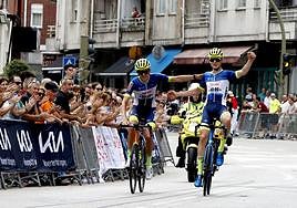 Jasper Schoofs, izquierda, y Gibe Staes entran de la mano en la meta en Los Corrales de Buelna.