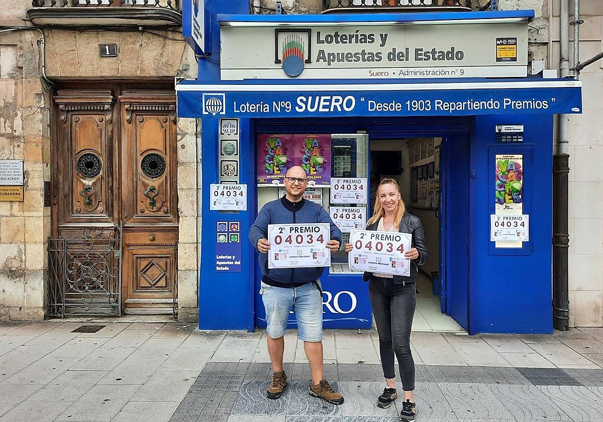 Los propietarios del establecimiento que ha repartido el premio en Santander posan con el número premiado.