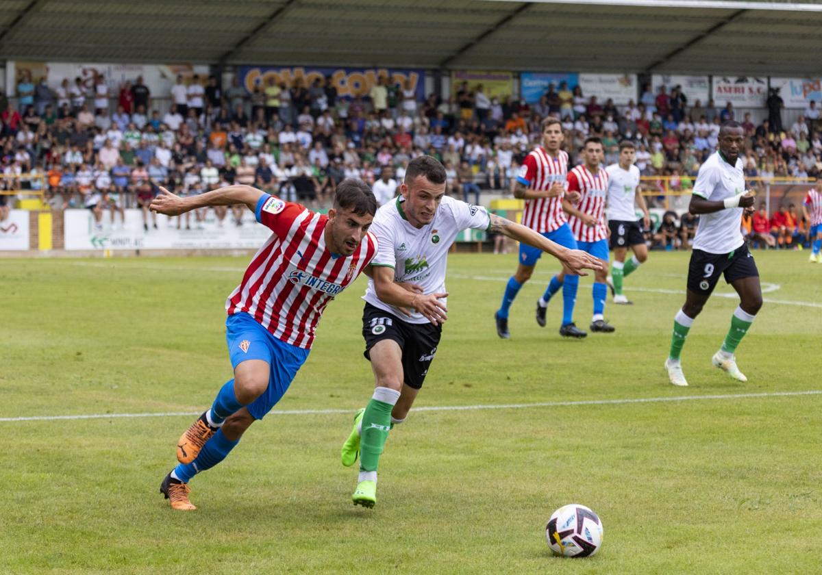 Íñigo Vicente pelea por la pelota con un jugador del Sporting durante el amistoso de la pasada campaña que cántabros y asturianos jugaron en Sarón.