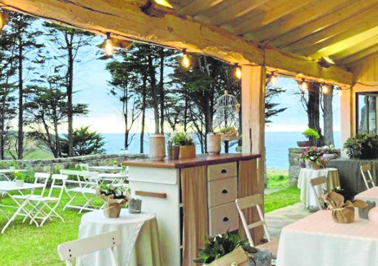 El local tiene una gran terraza ajardinada con vistas al mar.