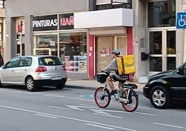 Un repartidor conduce una bicicleta eléctrica municipal, en Torrelavega.