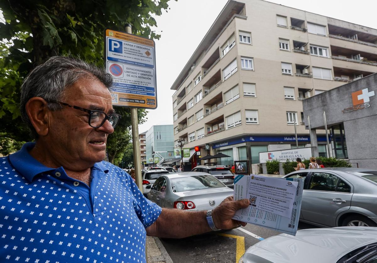 Enrique Blanco observa uno de los papeles orientativos sobre la ERA repartidos por el Ayuntamiento, ayer, en la Avenida de España.