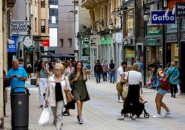 Vecinos y compradores caminan por una de las vías de mayor actividad comercial de Torrelavega.