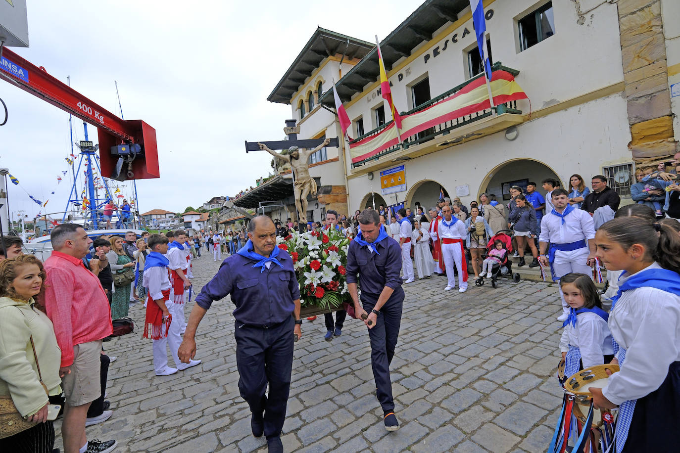 Los hombres ataviados de marineros con los colors del mar llevan de vuelta al Cristo hasta la iglesia. 