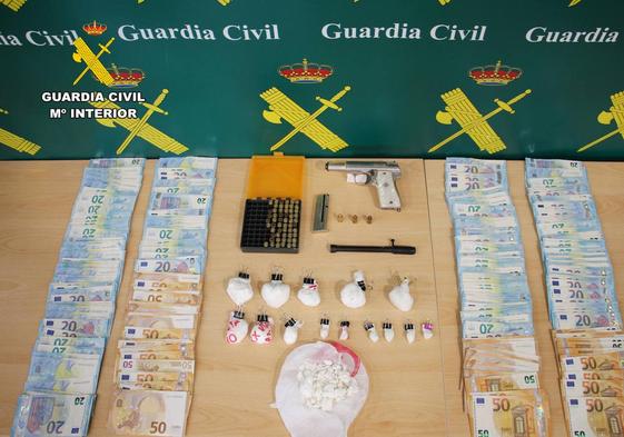 Droga, dinero y las armas y munición que fueron encontrados en la casa del detenido.