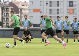 José Alberto, agachado, sigue las evoluciones de sus jugadores en el entrenamiento de ayer en La Albericia.