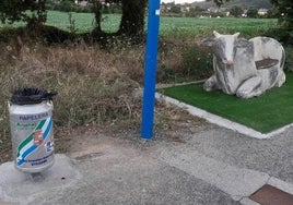 Una de las papeleras colocadas junto al banco con la figura de una vaca en El Gromo.