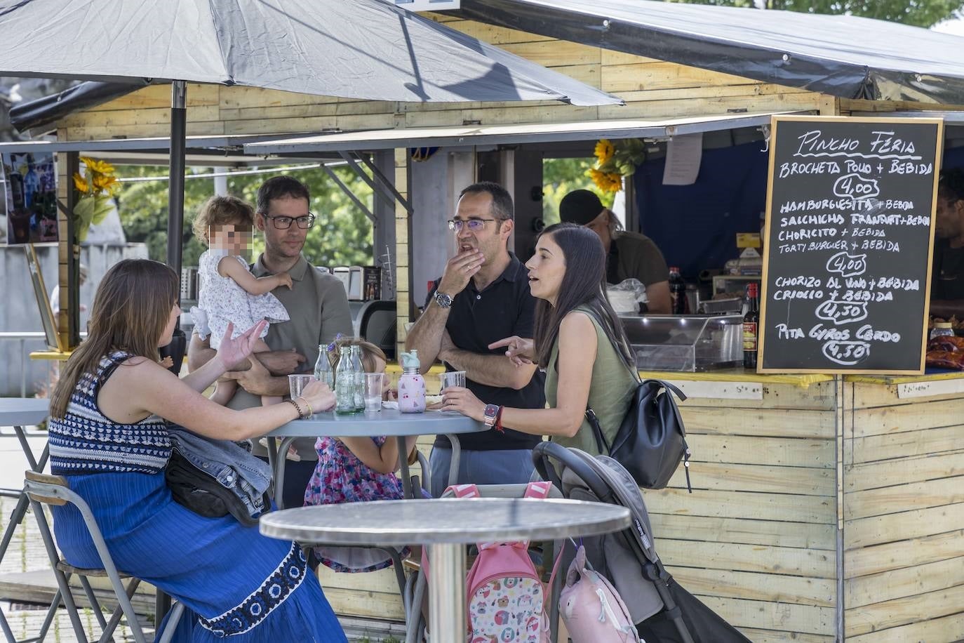 Una familia sentada en una mesa de las casetas de la Feria de Día de la Plaza Alfonso XIII.