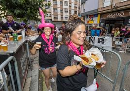 Dos chicas de la Peña La cresta de la ola recogiendo el menú del día.