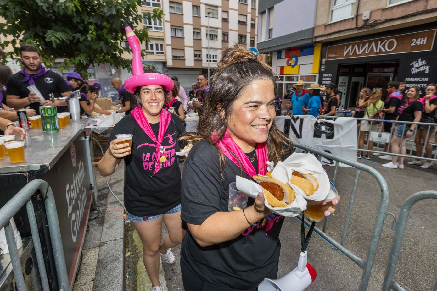 Dos chicas de la Peña La cresta de la Ola recogiendo su comida.