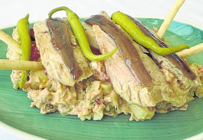 Ensaladilla rusa «de nuestra madre María Luisa» con ventresca de bonito, pimientos, piparras y anchoas.