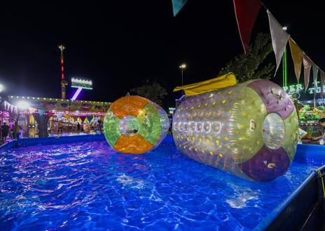 Imagen secundaria 1 - 1. Jóvenes esperando su turno en una de las atracciones. | 2. Una pareja disfrutando de los coches de choque. | 3. Una de las atracciones acuáticas.