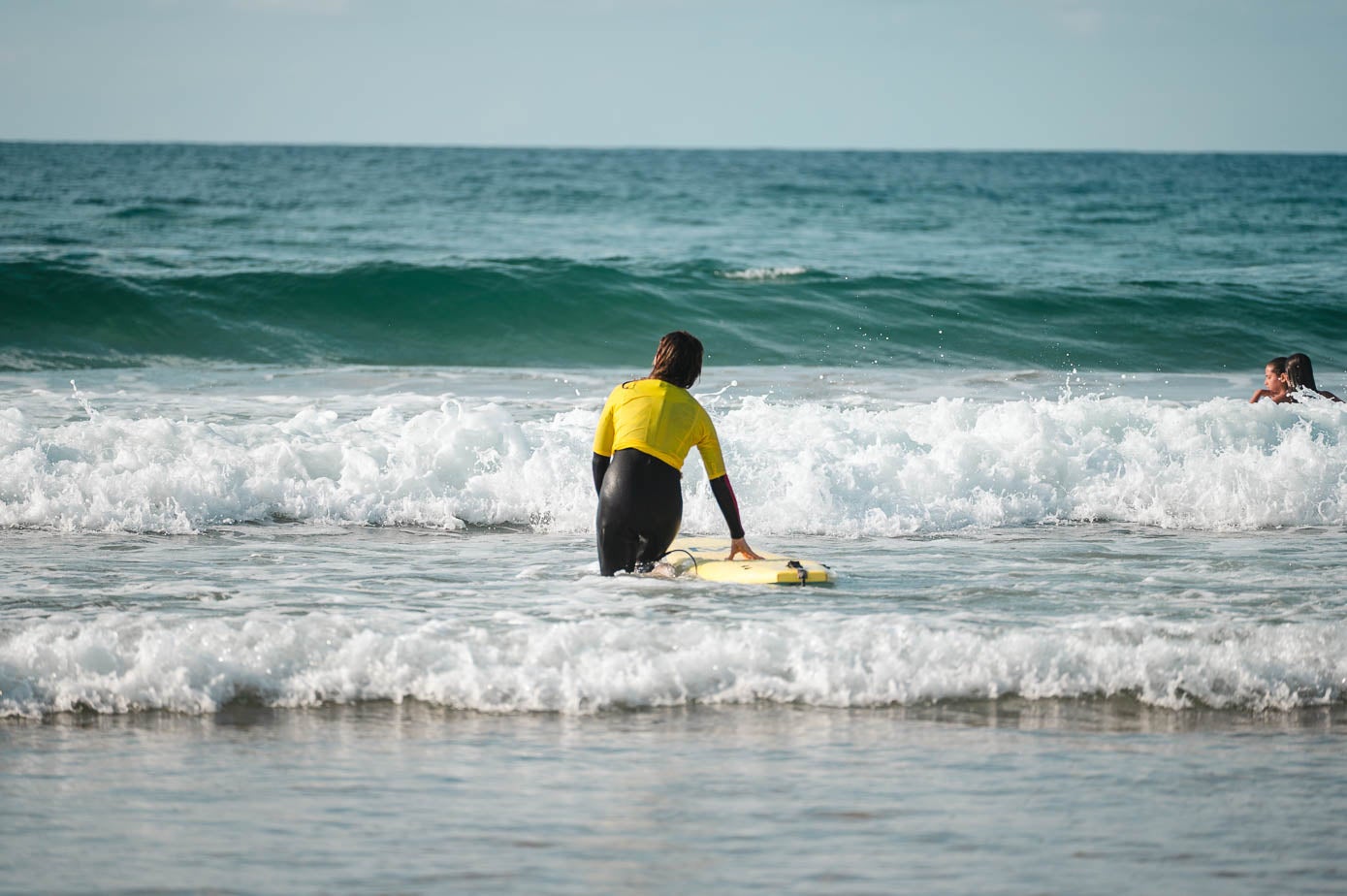 La periodista, con la tabla, metiéndose en el mar.