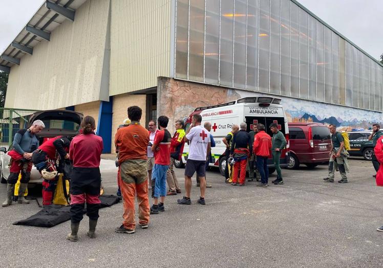 Imagen principal - Arriba, integrantes del dispositivo de rescate, el jueves junto al polideportivo del CEIP Jerónimo Pérez Sainz de la Maza, en La Gándara de Soba. Abajo, dos momentos del rescate y evacuación del cadáver este viernes. 