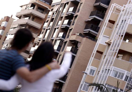 Una pareja que busca alquilar una vivienda señala un bloque de pisos, en una imagen de archivo.