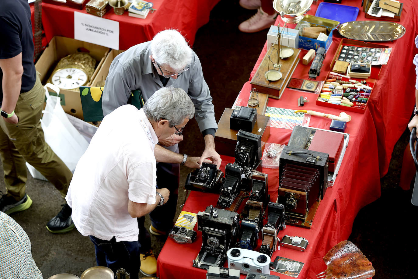 Dos visitantes observan una colección de cámaras antiguas