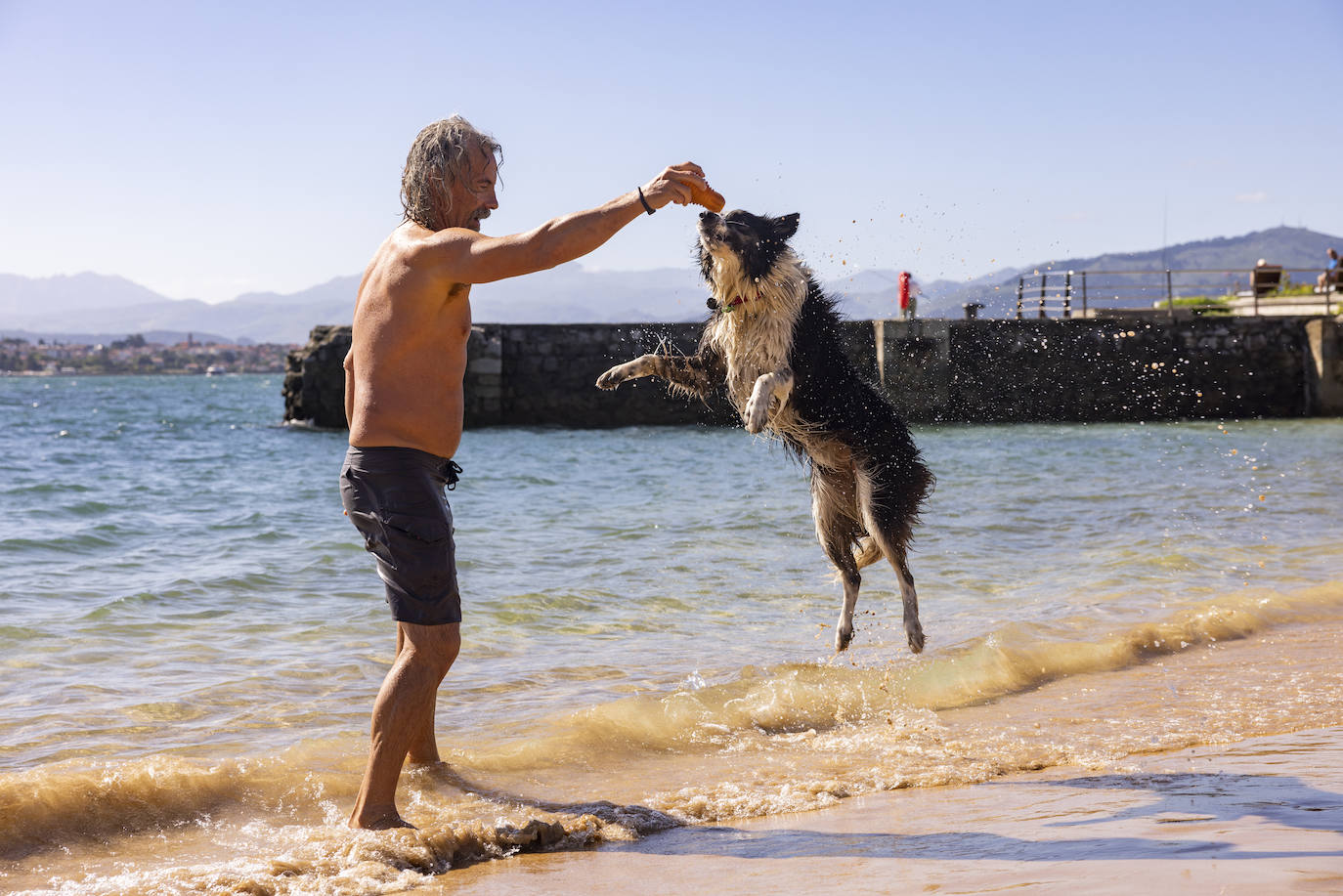 Un hombre juega con su perro en Los Peligros