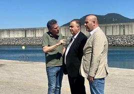 El Patrón Mayor de la Cofradía de Pescadores, César Nates, explica el proyecto de ampliación al Consejero de Fomento, Roberto Media, y el alcalde de Laredo, Miguel González