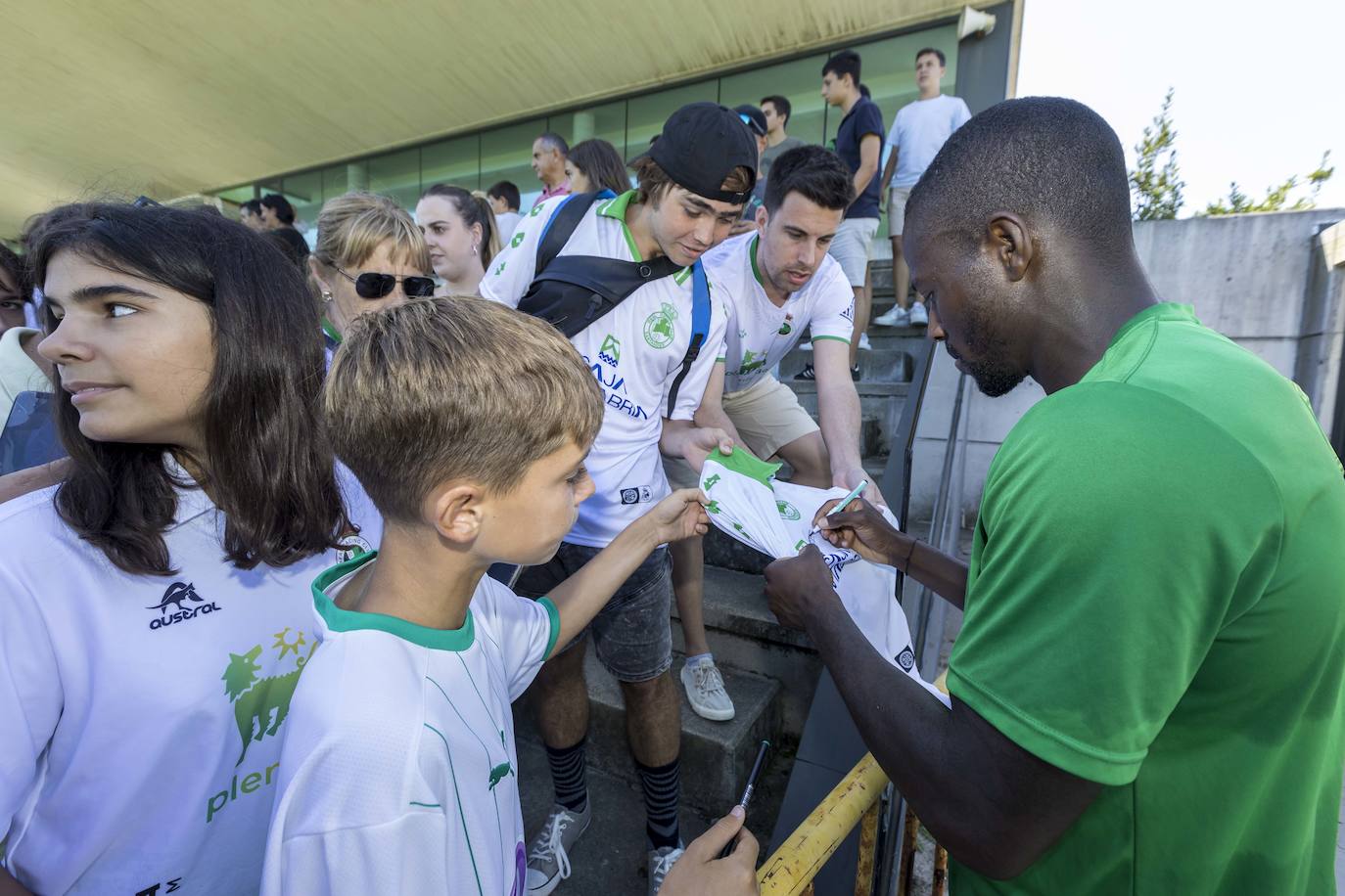 Cedric estampa su firma en una camiseta.