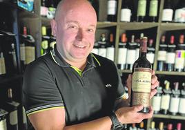 Eduardo sostiene una botella de Viña Albina en la bodega de un restaurante de Cantabria.